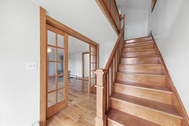 staircase with french doors and hardwood / wood-style flooring