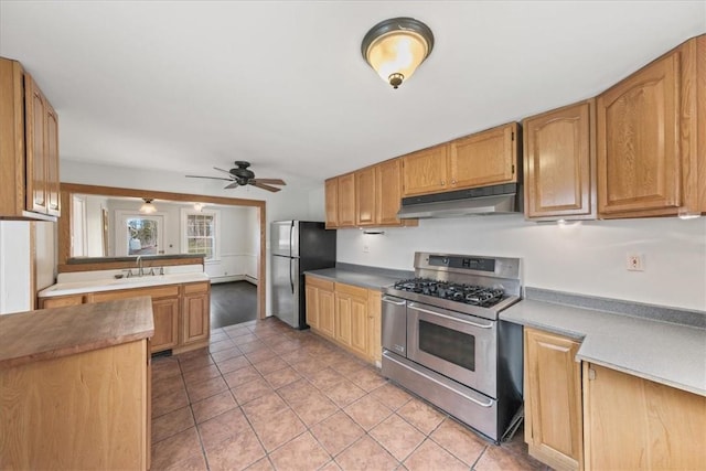 kitchen with ceiling fan, light tile patterned flooring, sink, and stainless steel appliances