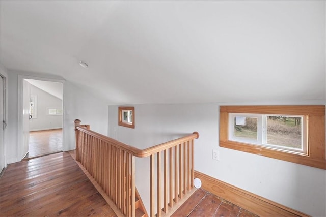 hallway with hardwood / wood-style floors and vaulted ceiling