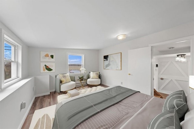 bedroom with hardwood / wood-style floors and multiple windows