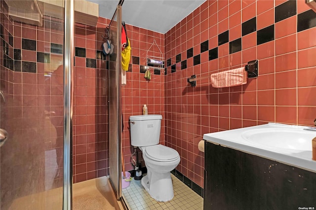 bathroom featuring walk in shower, vanity, tile walls, tile patterned flooring, and toilet