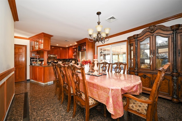 dining area with crown molding and a notable chandelier