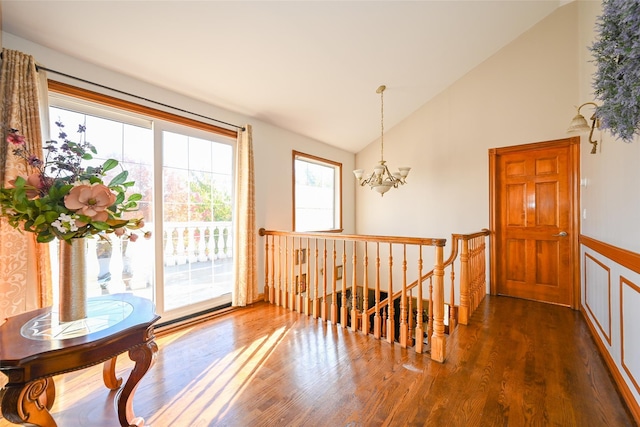 doorway featuring a chandelier, high vaulted ceiling, and dark wood-type flooring