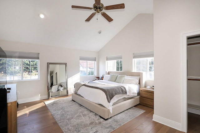 bedroom featuring dark hardwood / wood-style floors, high vaulted ceiling, and ceiling fan