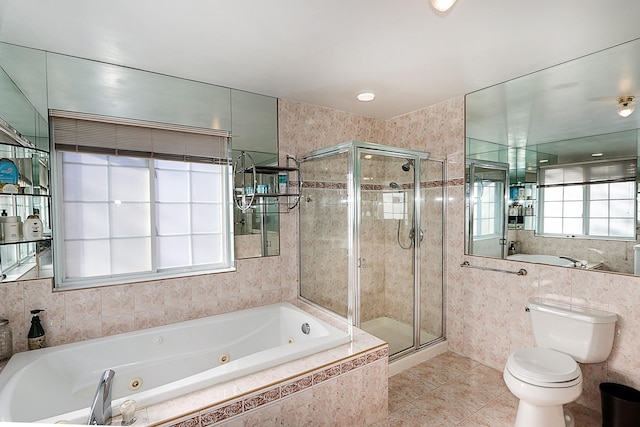 bathroom with tile patterned flooring, separate shower and tub, toilet, and tile walls