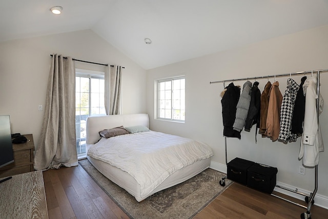 bedroom with dark hardwood / wood-style flooring, multiple windows, and lofted ceiling