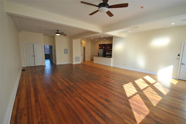 unfurnished living room with ceiling fan, beam ceiling, and dark wood-type flooring