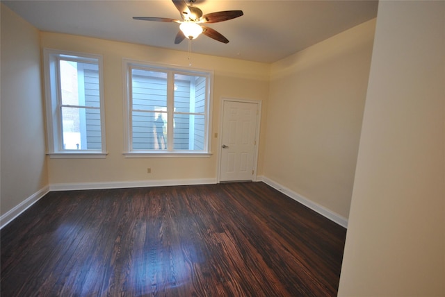 spare room with dark hardwood / wood-style flooring and ceiling fan