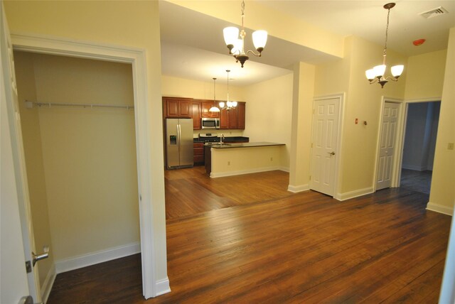 kitchen with a chandelier, stainless steel appliances, and dark hardwood / wood-style floors