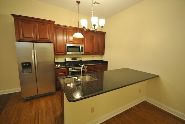 kitchen with an inviting chandelier, sink, hanging light fixtures, dark hardwood / wood-style floors, and appliances with stainless steel finishes