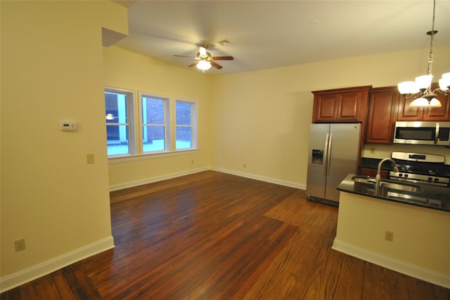 kitchen featuring ceiling fan with notable chandelier, dark hardwood / wood-style flooring, stainless steel appliances, and decorative light fixtures