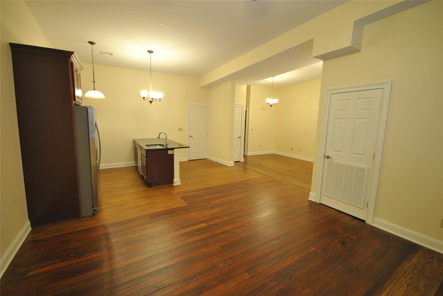 unfurnished room with a chandelier, dark hardwood / wood-style floors, and sink