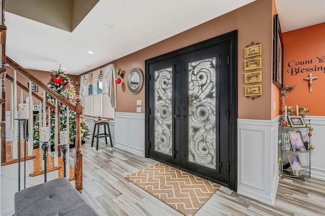 foyer entrance featuring light hardwood / wood-style floors and french doors