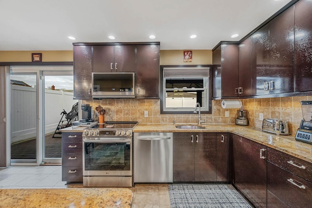 kitchen featuring decorative backsplash, dark brown cabinetry, sink, and appliances with stainless steel finishes