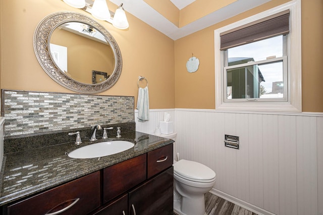 bathroom featuring backsplash, hardwood / wood-style flooring, vanity, and toilet