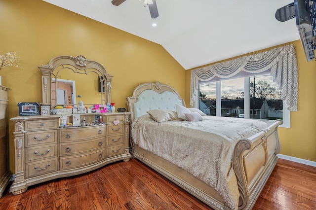 bedroom with dark hardwood / wood-style flooring, vaulted ceiling, and ceiling fan