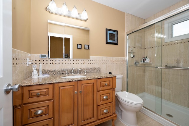 bathroom with vanity, tile patterned flooring, toilet, tile walls, and an enclosed shower