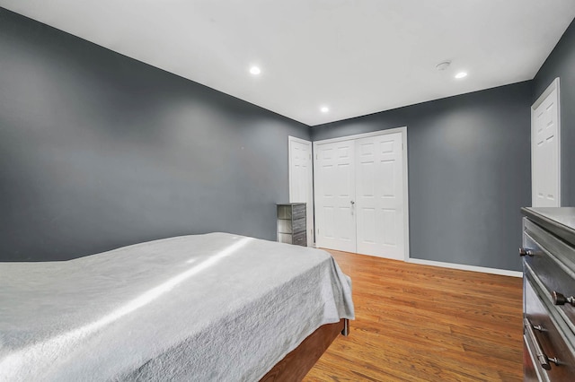 bedroom with hardwood / wood-style floors and a closet