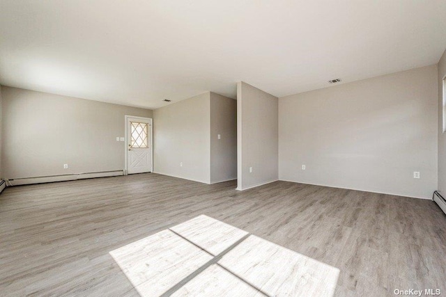 spare room with light hardwood / wood-style floors and a baseboard heating unit