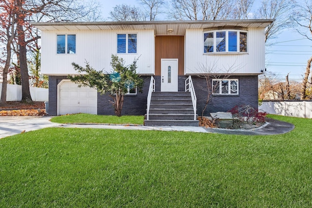 split foyer home featuring a garage and a front lawn