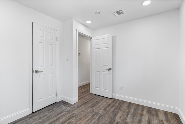 unfurnished bedroom featuring a closet and dark hardwood / wood-style flooring