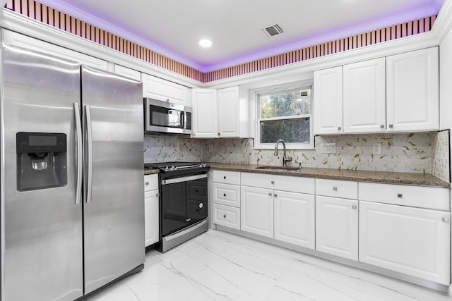 kitchen with sink, dark stone counters, decorative backsplash, white cabinets, and appliances with stainless steel finishes