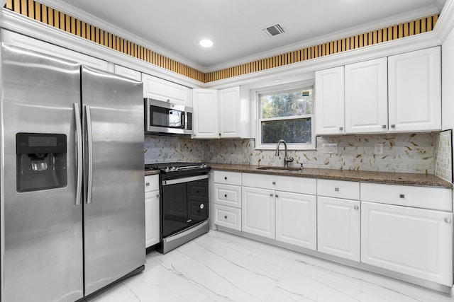 kitchen with dark stone counters, sink, appliances with stainless steel finishes, tasteful backsplash, and white cabinetry