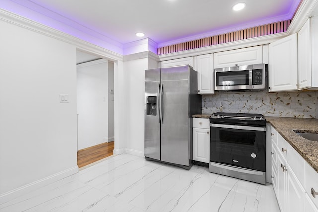 kitchen with white cabinets, crown molding, dark stone countertops, tasteful backsplash, and stainless steel appliances