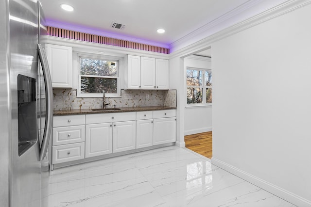 kitchen featuring white cabinets, a healthy amount of sunlight, stainless steel fridge with ice dispenser, and sink