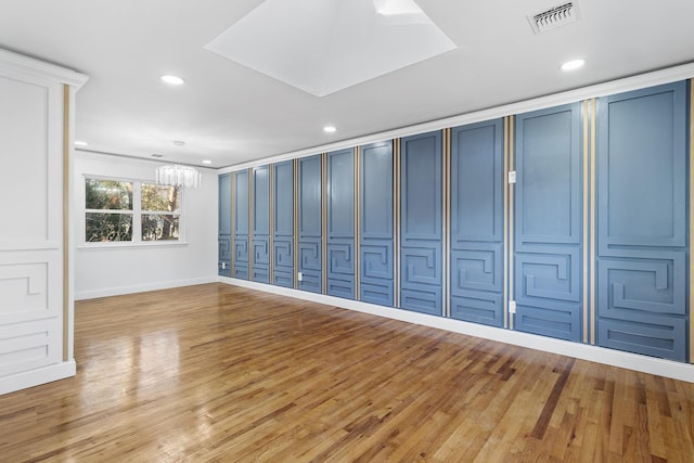 empty room featuring light wood-type flooring and a notable chandelier