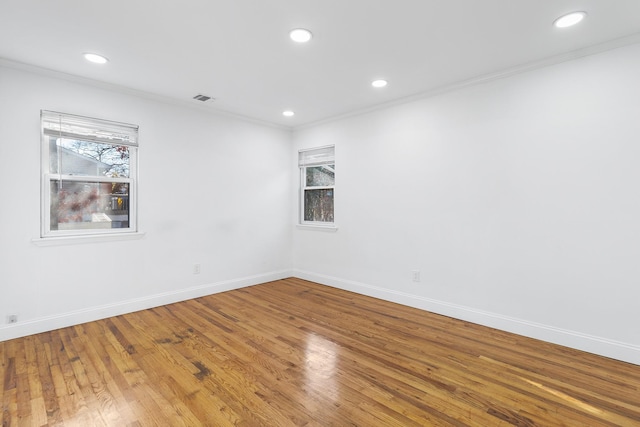 spare room featuring hardwood / wood-style floors and crown molding