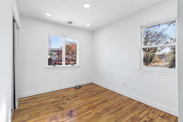 unfurnished room with hardwood / wood-style flooring