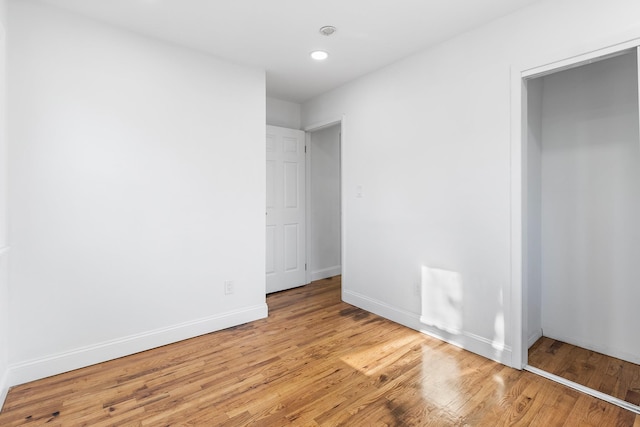 unfurnished bedroom featuring light wood-type flooring and a closet