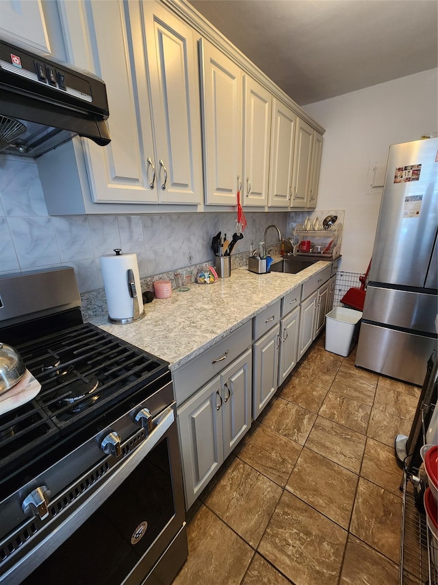 kitchen with tasteful backsplash, stainless steel appliances, exhaust hood, sink, and gray cabinets