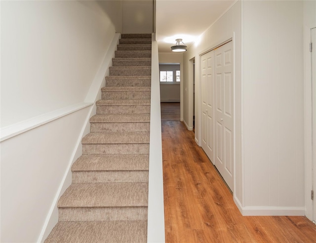 staircase with baseboards and wood finished floors