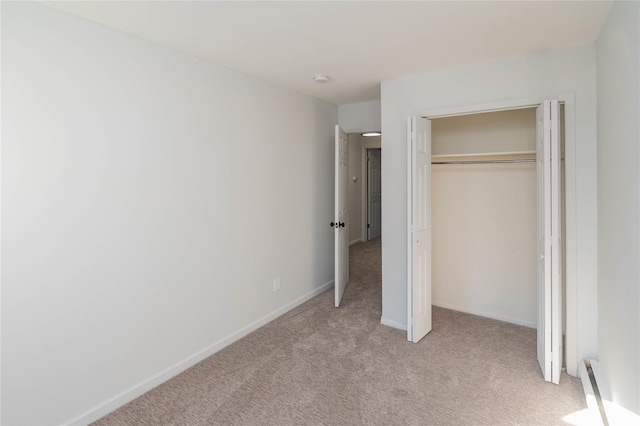 unfurnished bedroom featuring a closet, light colored carpet, and baseboards