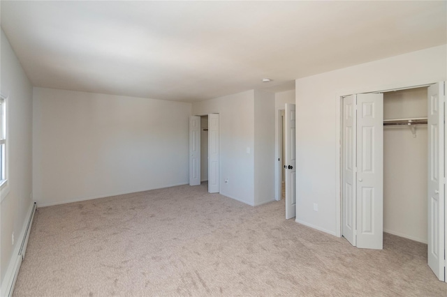 unfurnished bedroom featuring a baseboard radiator, carpet, baseboards, and multiple closets