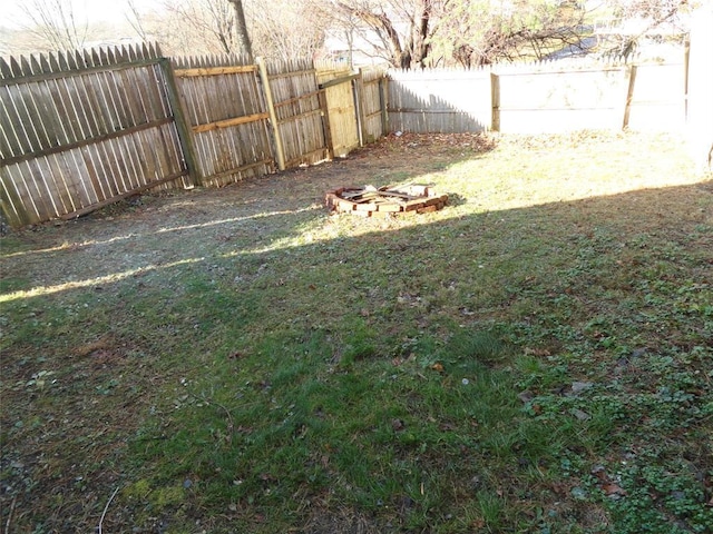 view of yard featuring an outdoor fire pit and a fenced backyard