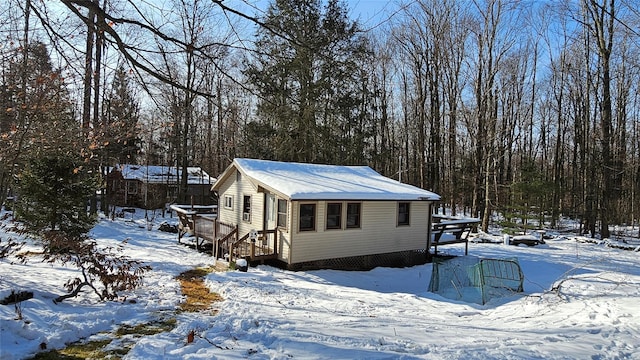 view of snowy exterior with a deck