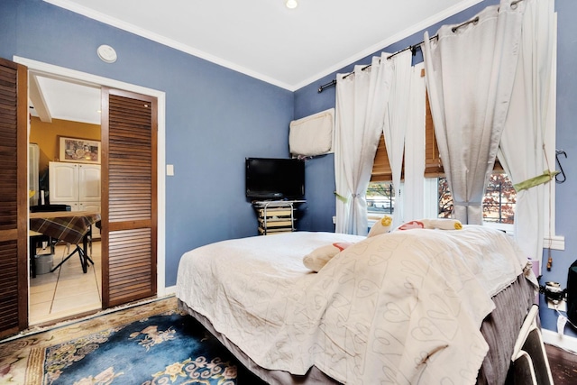 bedroom with wood-type flooring, a closet, and crown molding