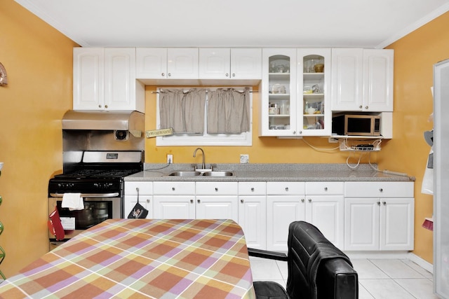 kitchen featuring sink, light tile patterned floors, ornamental molding, appliances with stainless steel finishes, and white cabinetry