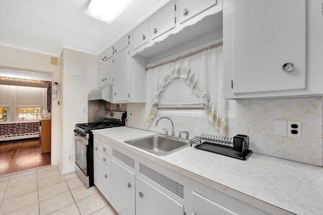 kitchen featuring sink, baseboard heating, stainless steel range with gas cooktop, crown molding, and light tile patterned floors