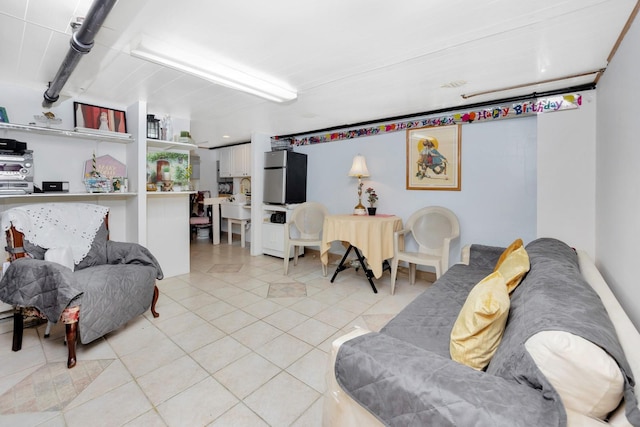 living room featuring beam ceiling and light tile patterned flooring