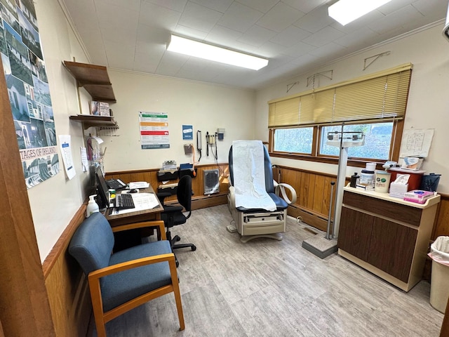 office space with wood finished floors, wainscoting, wood walls, and crown molding