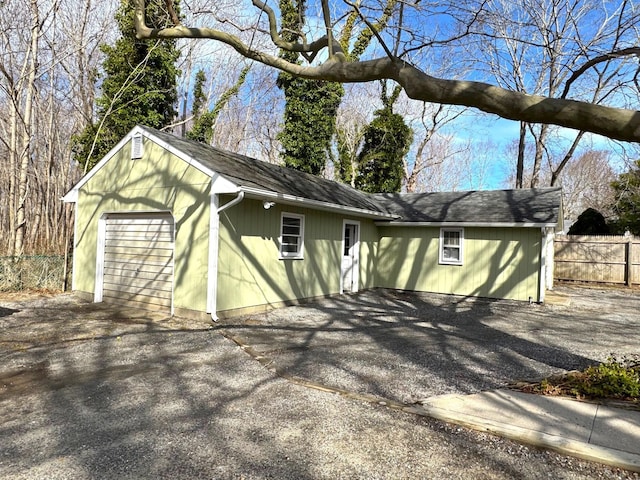 view of side of property featuring asphalt driveway