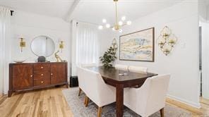 dining space featuring light hardwood / wood-style floors and a notable chandelier