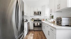 kitchen featuring appliances with stainless steel finishes, dark hardwood / wood-style flooring, and white cabinetry