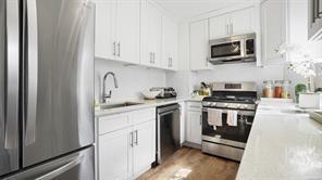 kitchen with dark hardwood / wood-style flooring, white cabinetry, sink, and appliances with stainless steel finishes