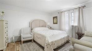 bedroom with light hardwood / wood-style floors and radiator