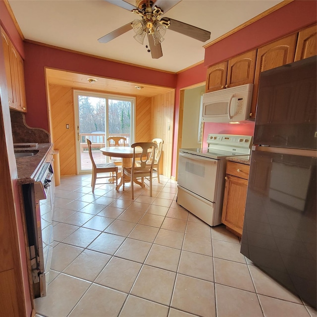 kitchen with ceiling fan, wood walls, light tile patterned floors, and white appliances